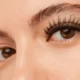 Close-up of a woman's eyes showcasing voluminous eyelash extensions and well-defined, natural-looking eyebrows.