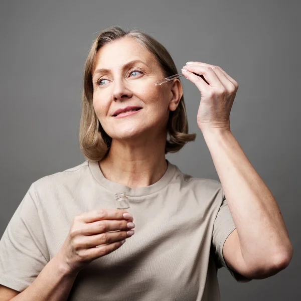 Une femme met ses lentilles de contact, concentrée devant un miroir.