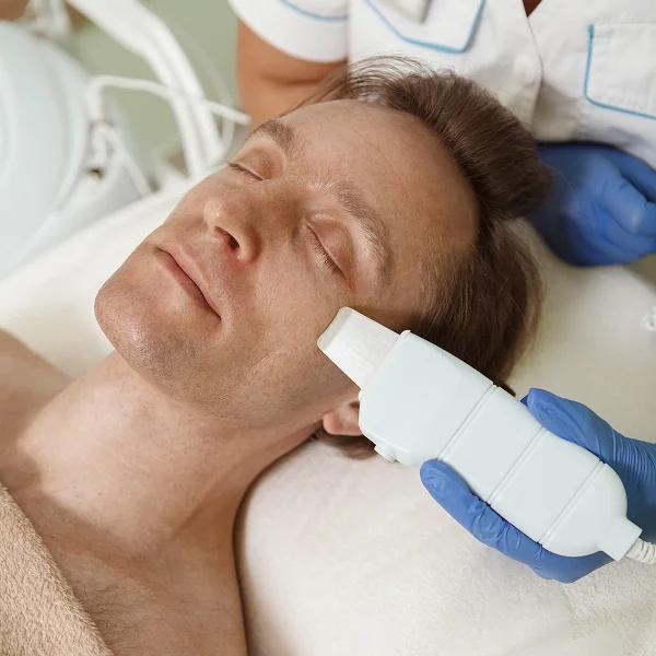 A man lying in a hospital bed with a facial radiofrequency device attached to his head.