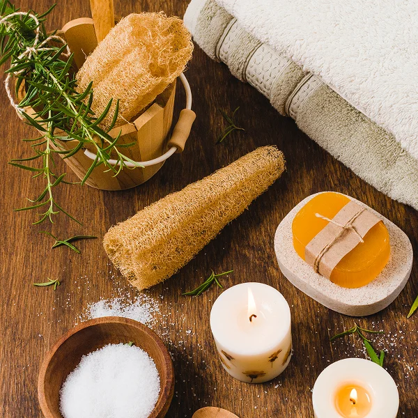 A wooden table adorned with a towel, candles, and various spa items, set in a serene hammam spa environment.