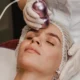 Une femme reçoit un traitement facial avec un appareil de radiofréquence sur le visage.