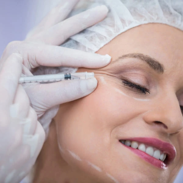 Une femme reçoit une injection faciale dans un cadre médical.